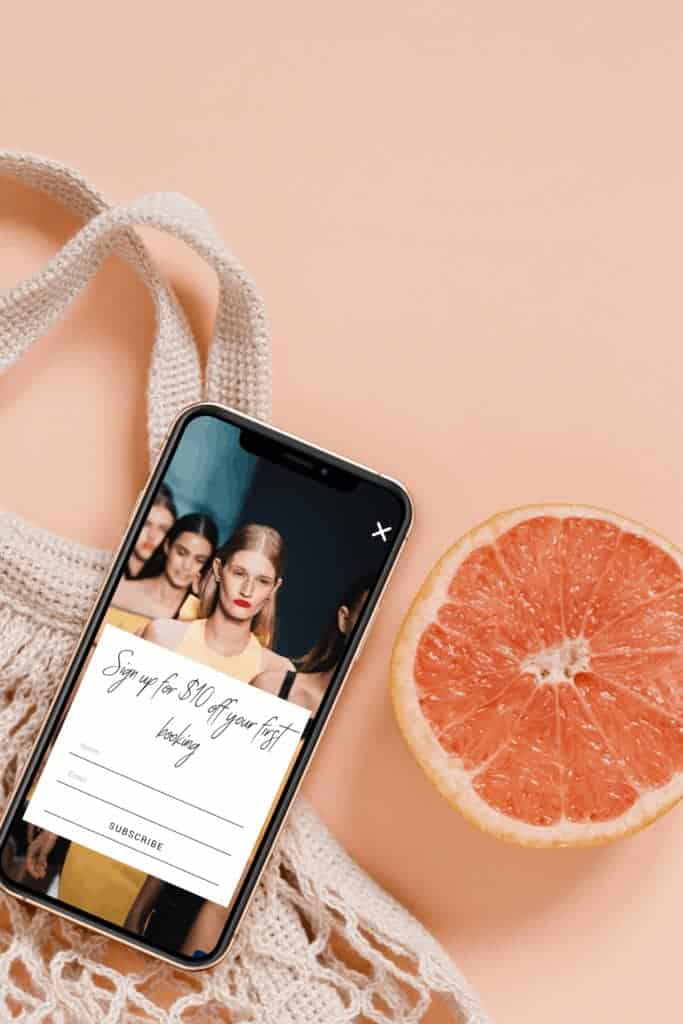 A woman's phone displays a photo of a woman and grapefruit, showcasing the brand design on a WordPress website.